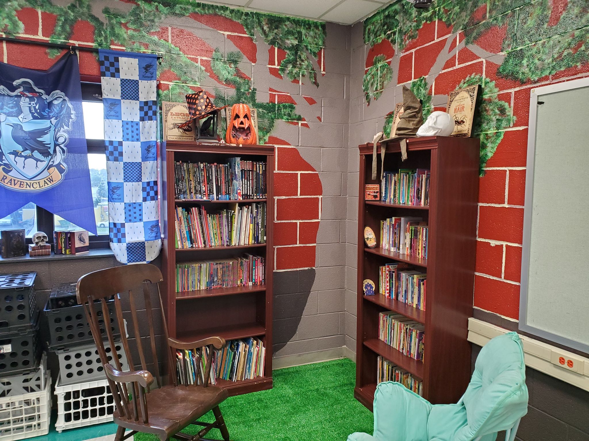 Corner of the 4th grade classroom with a painting of the Whomping Willow on the wall, books, and chairs.